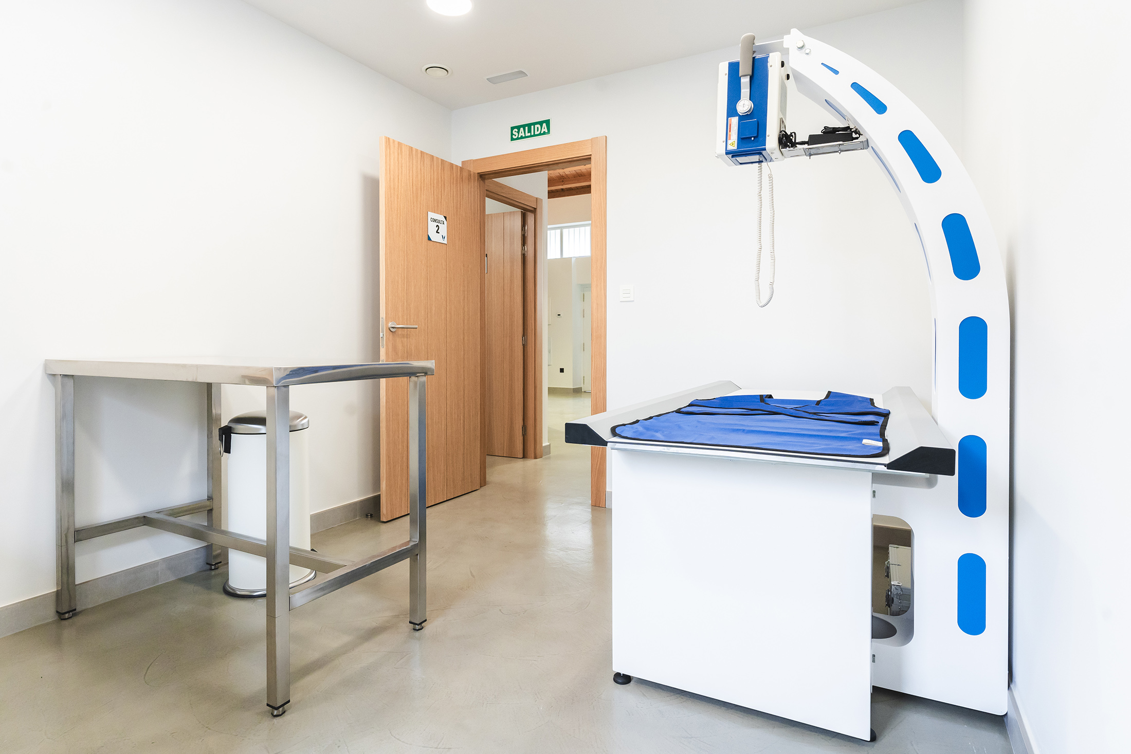 Sala de exploración veterinaria con camilla elevable y equipamiento médico